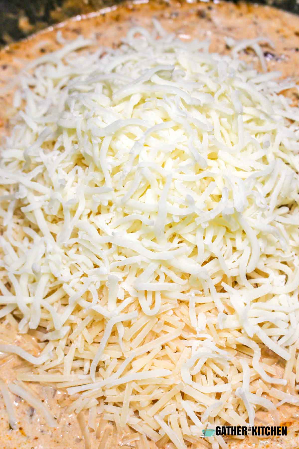 Parmesan cheese added to pasta sauce mixture.