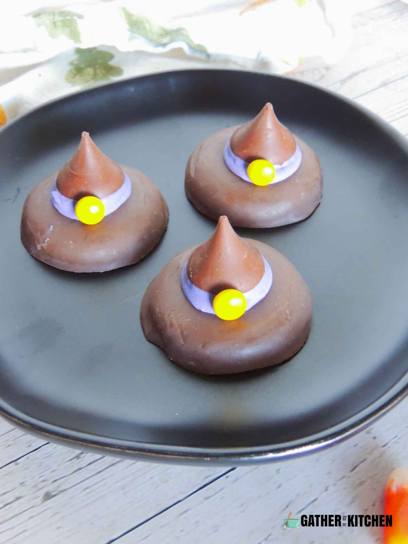 Three witch hat cookies on a plate.