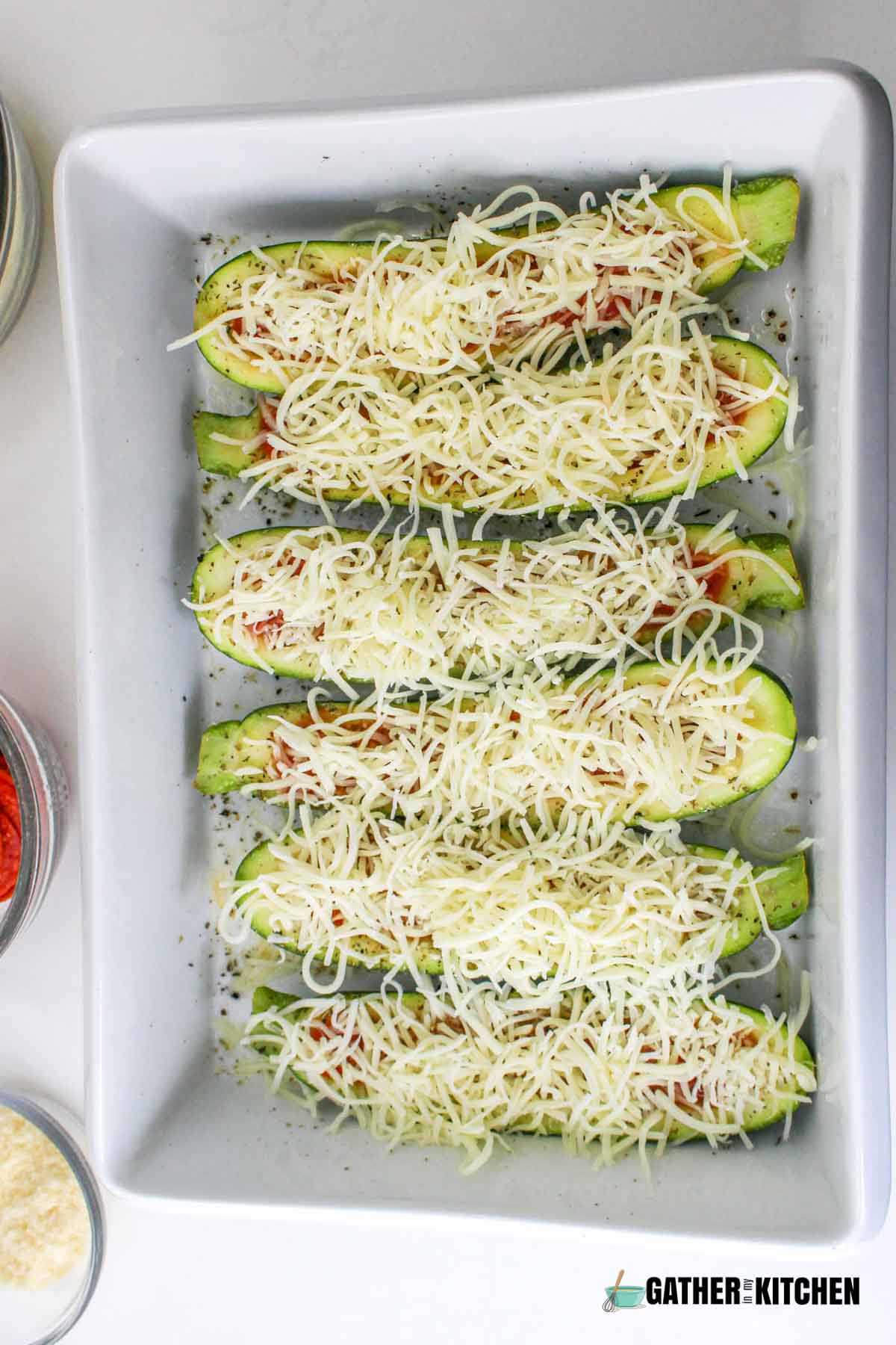 Shredded mozzarella sprinkled on top of zucchini.
