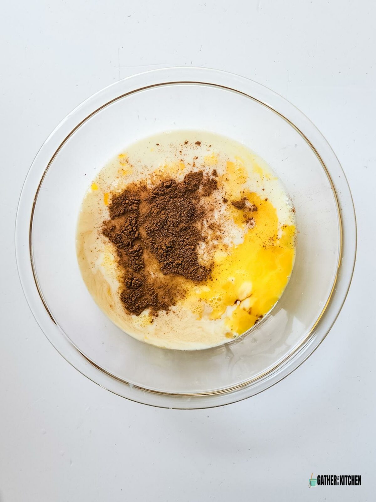 Eggs, sugar, milk, cinnamon, nutmeg and vanilla in a bowl.