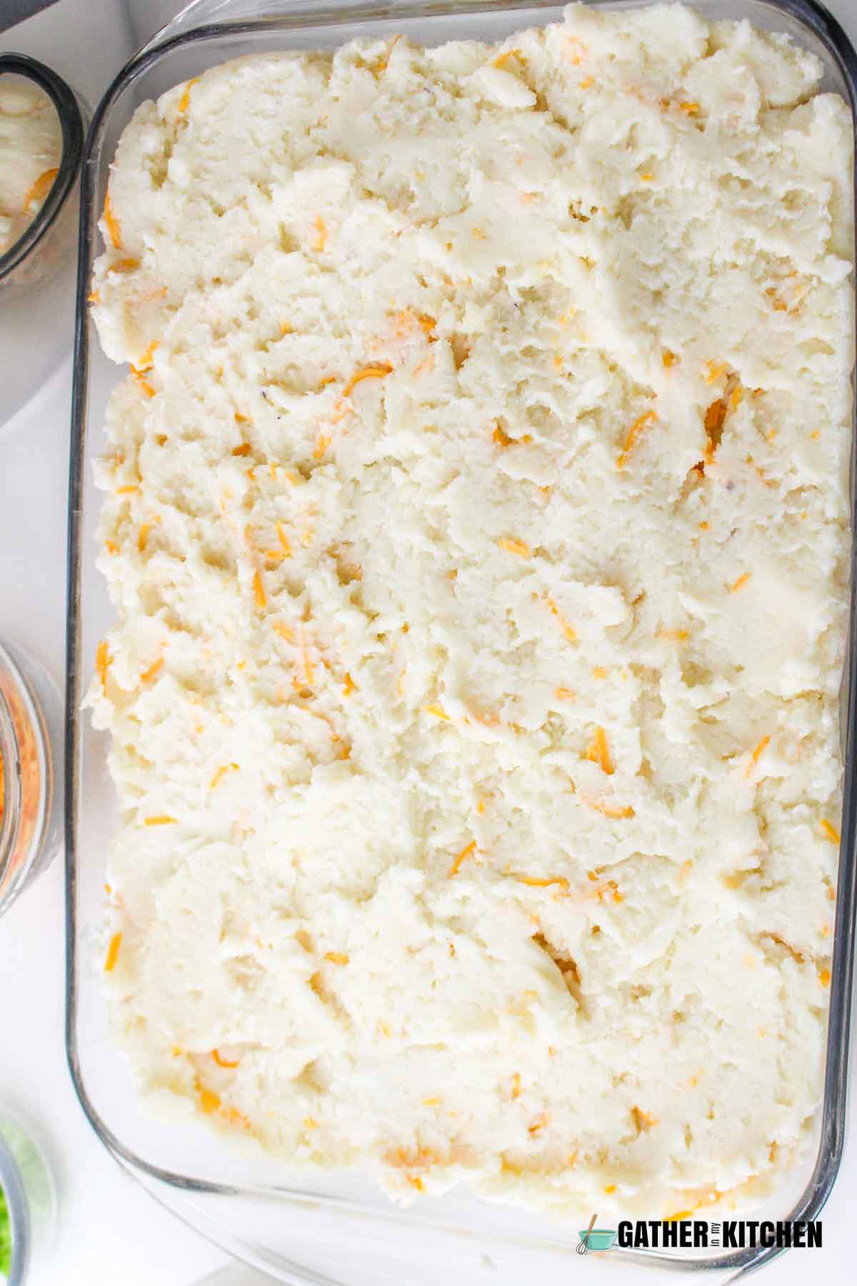 Mashed potatoes spread in baking dish.