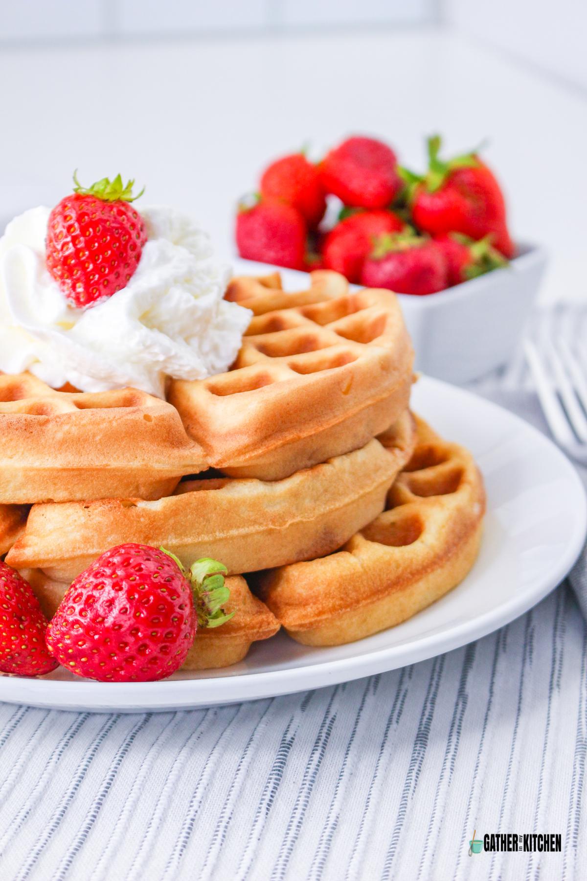 A plate of Pancake Mix Waffles with strawberries and cream.