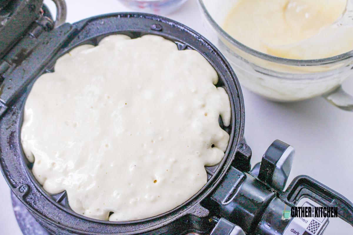 Pancake batter poured on waffle maker.