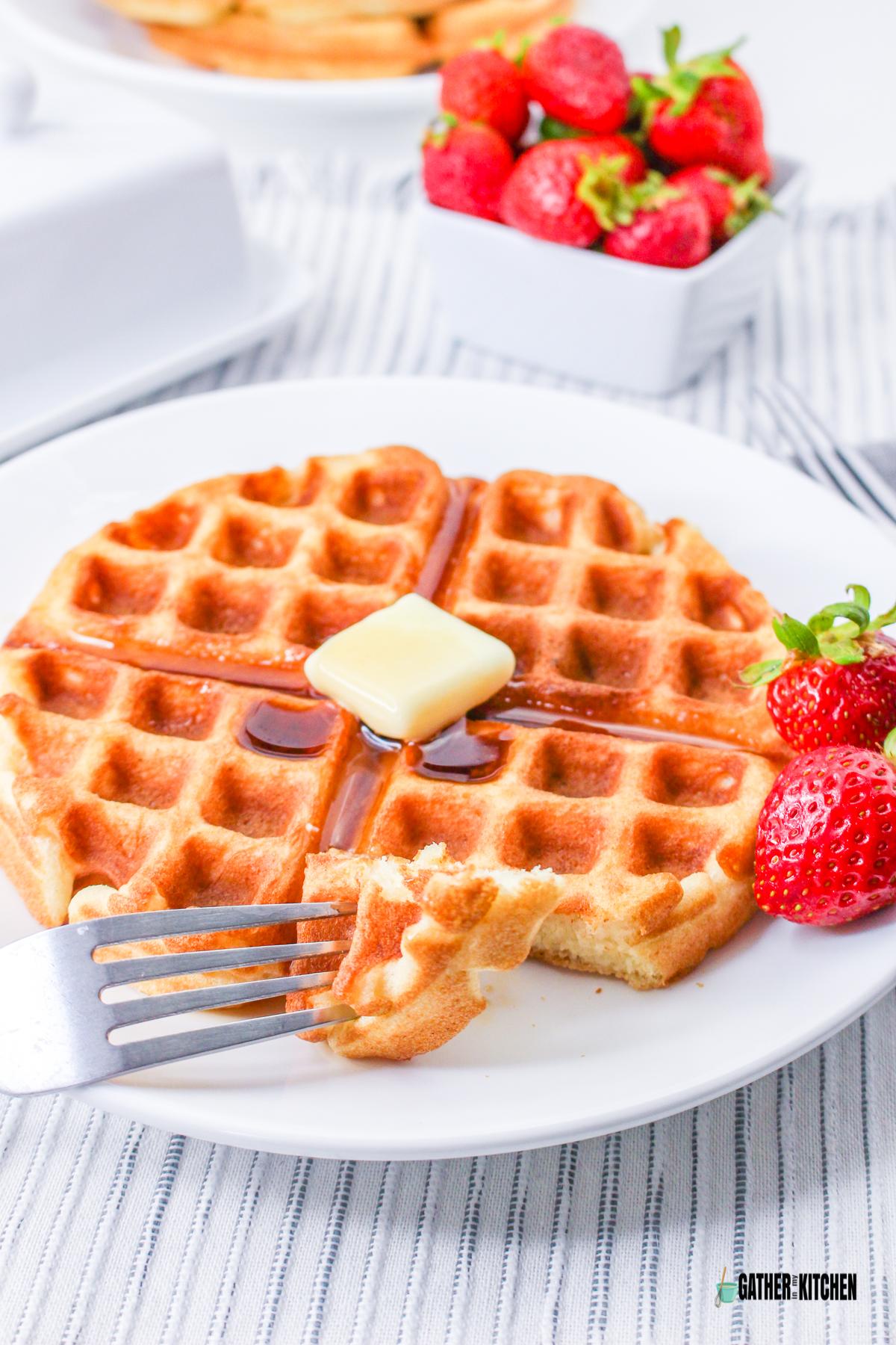 A plate of Pancake Mix Waffle and a fork with a portion of the waffle.