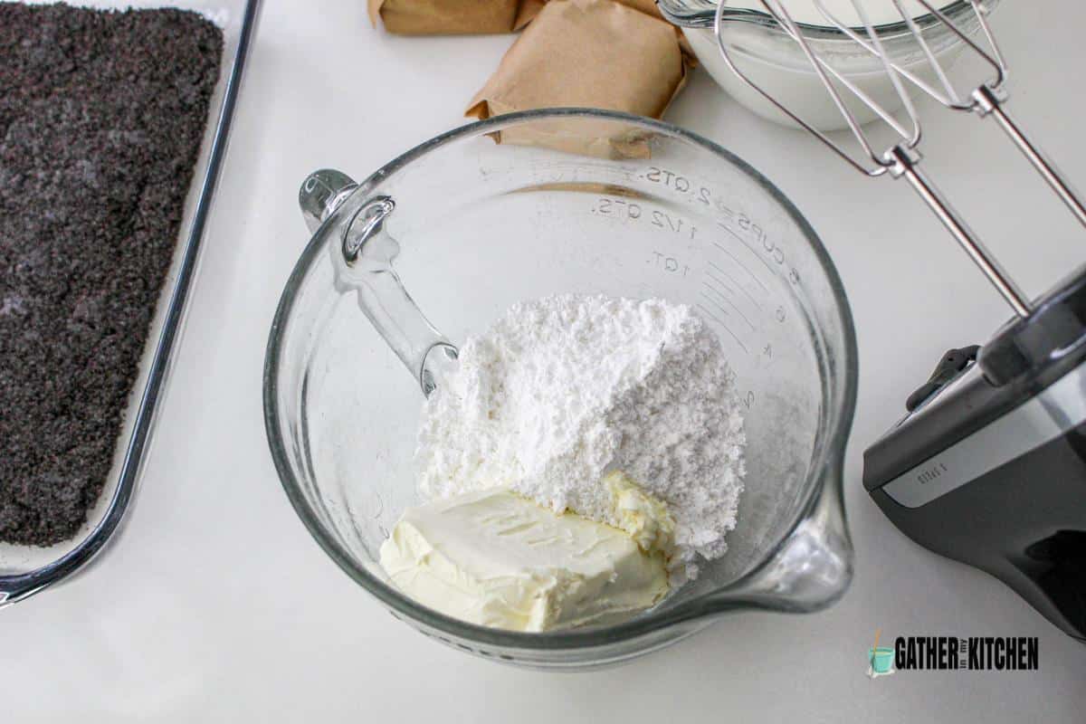 Mixing bowl with cream cheese and powdered sugar.