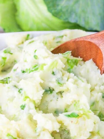 Colcannon Potatoes in a dish with a serving spoon.