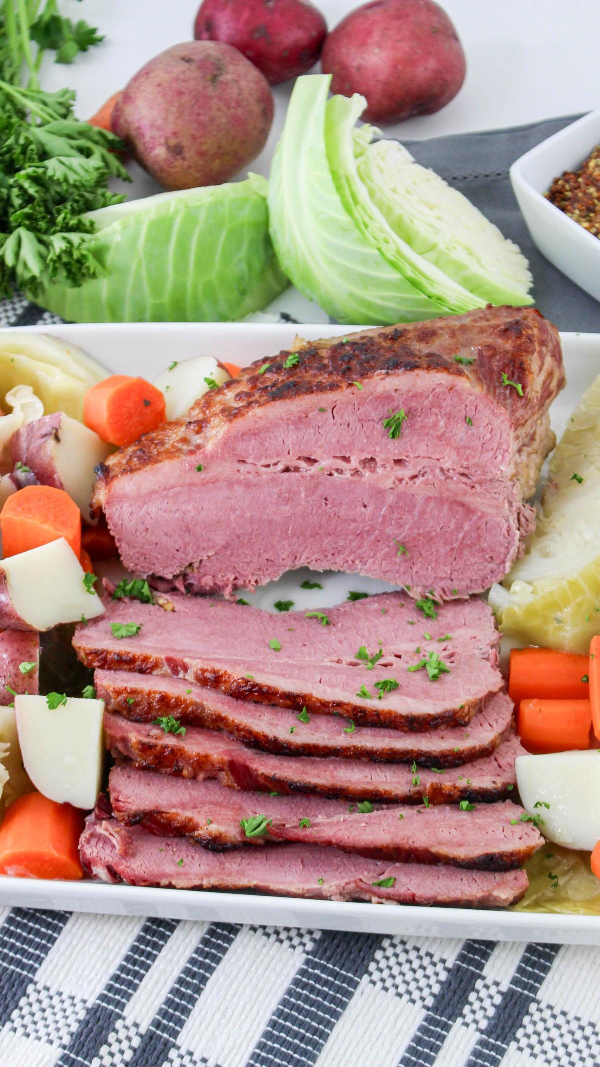 Sliced corned beef with veggies on a platter.