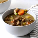 Irish stew in a bowl with a spoonful being lifted.