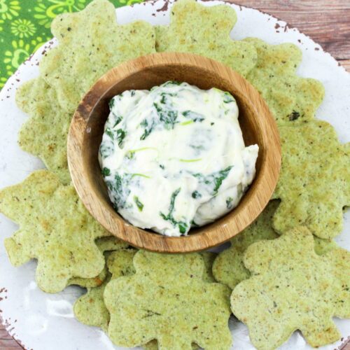 St. Patrick's Day dip in a bowl surrounded by four leaf clover chips.
