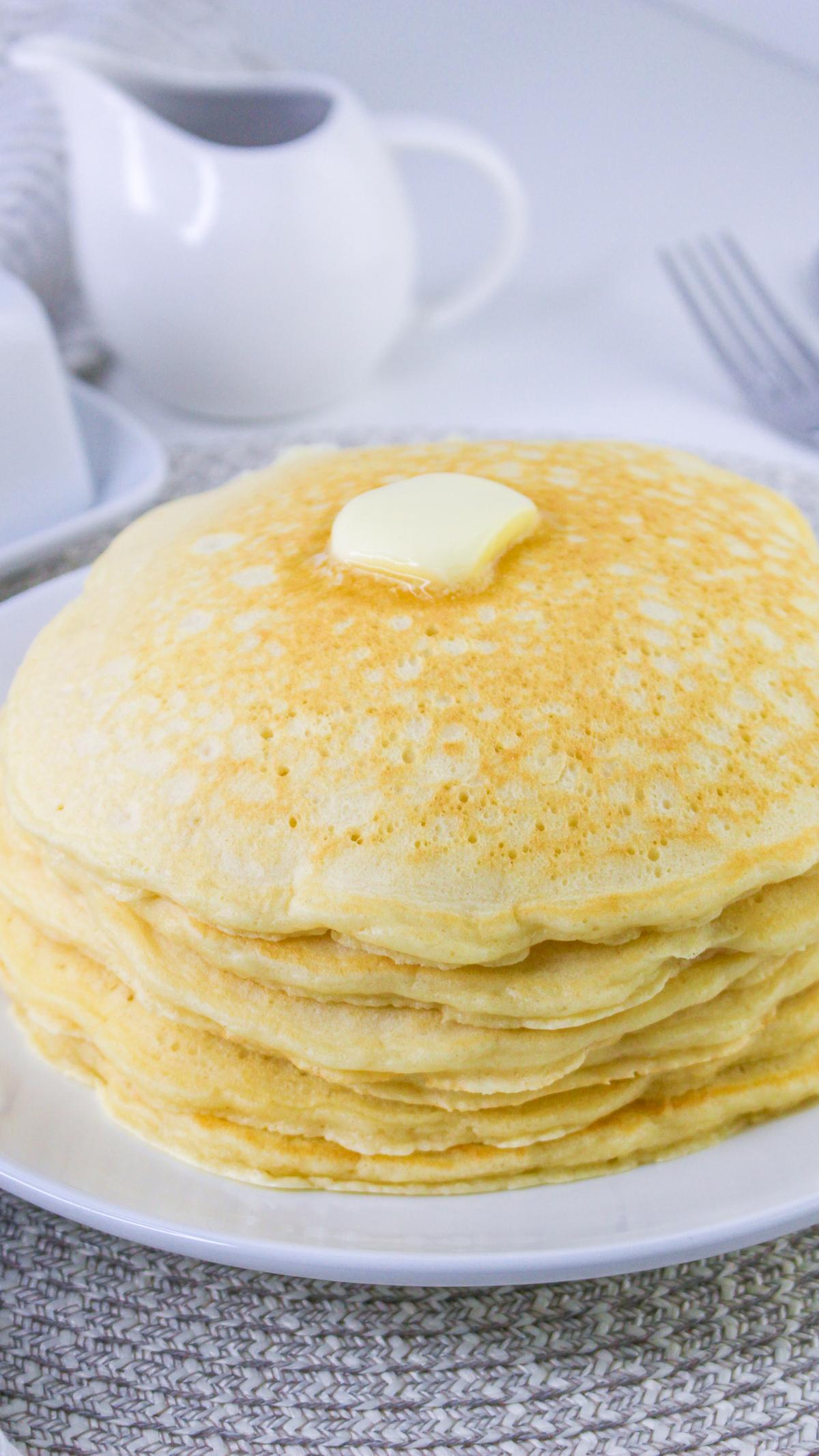 Stack of sweet cream pancakes with a pat of butter on top.