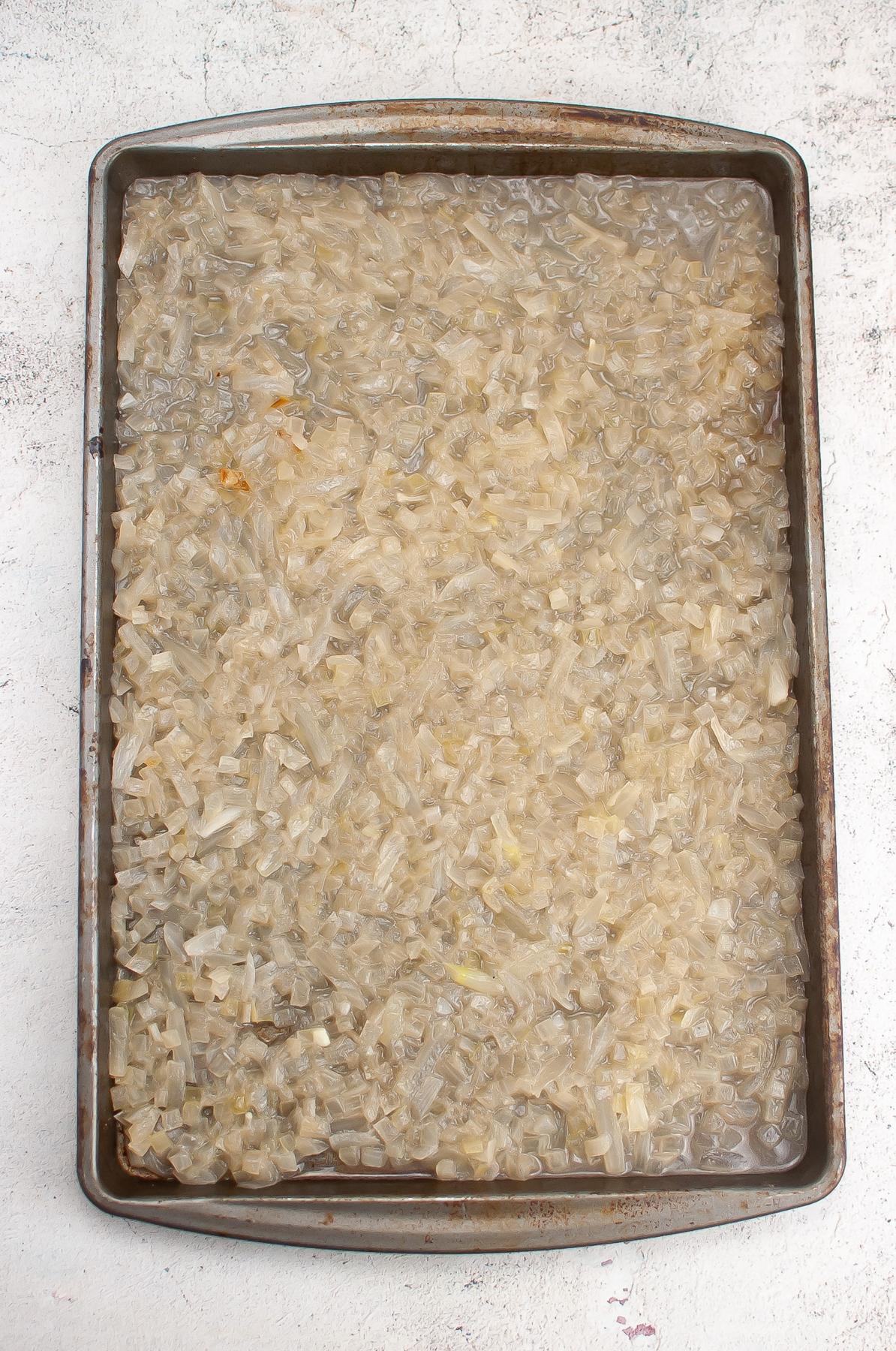 Shallow sheet pan with onion mixture.