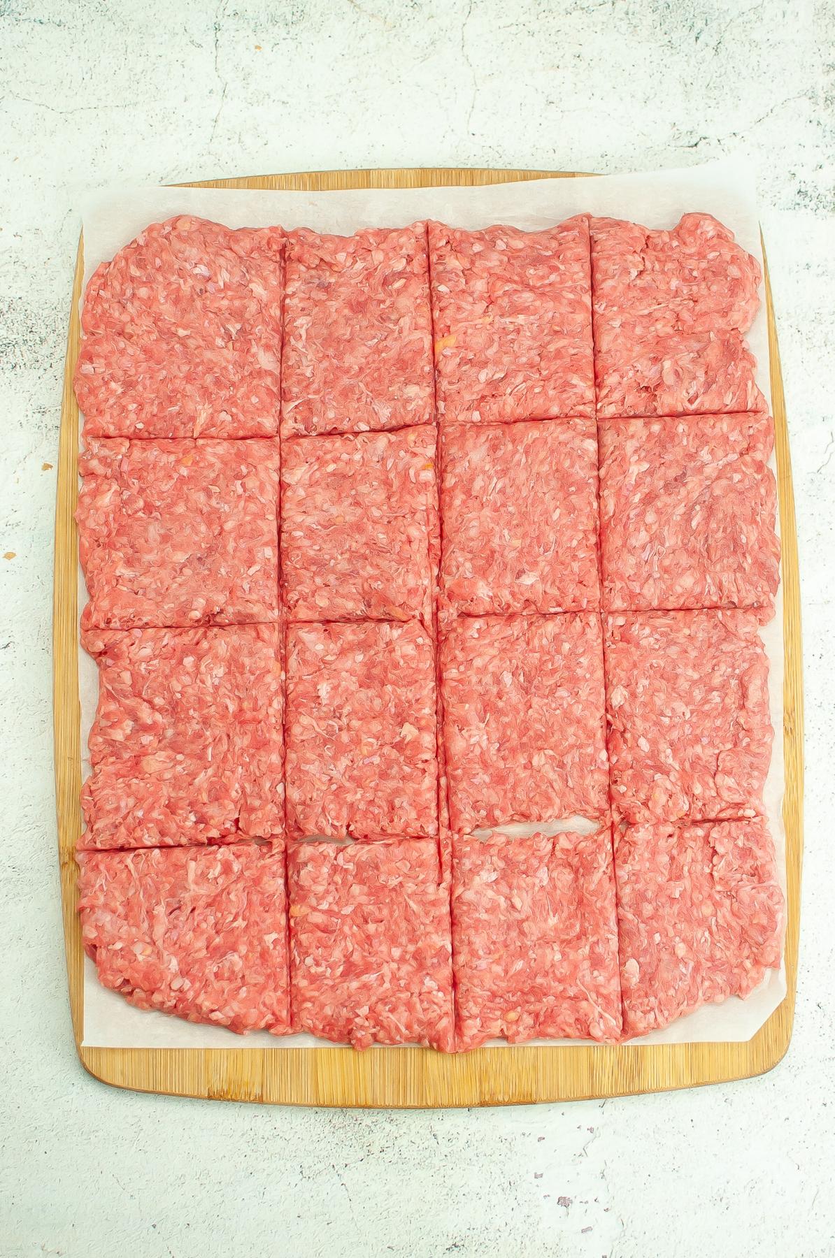 Flattened meat divided into 16 squares.