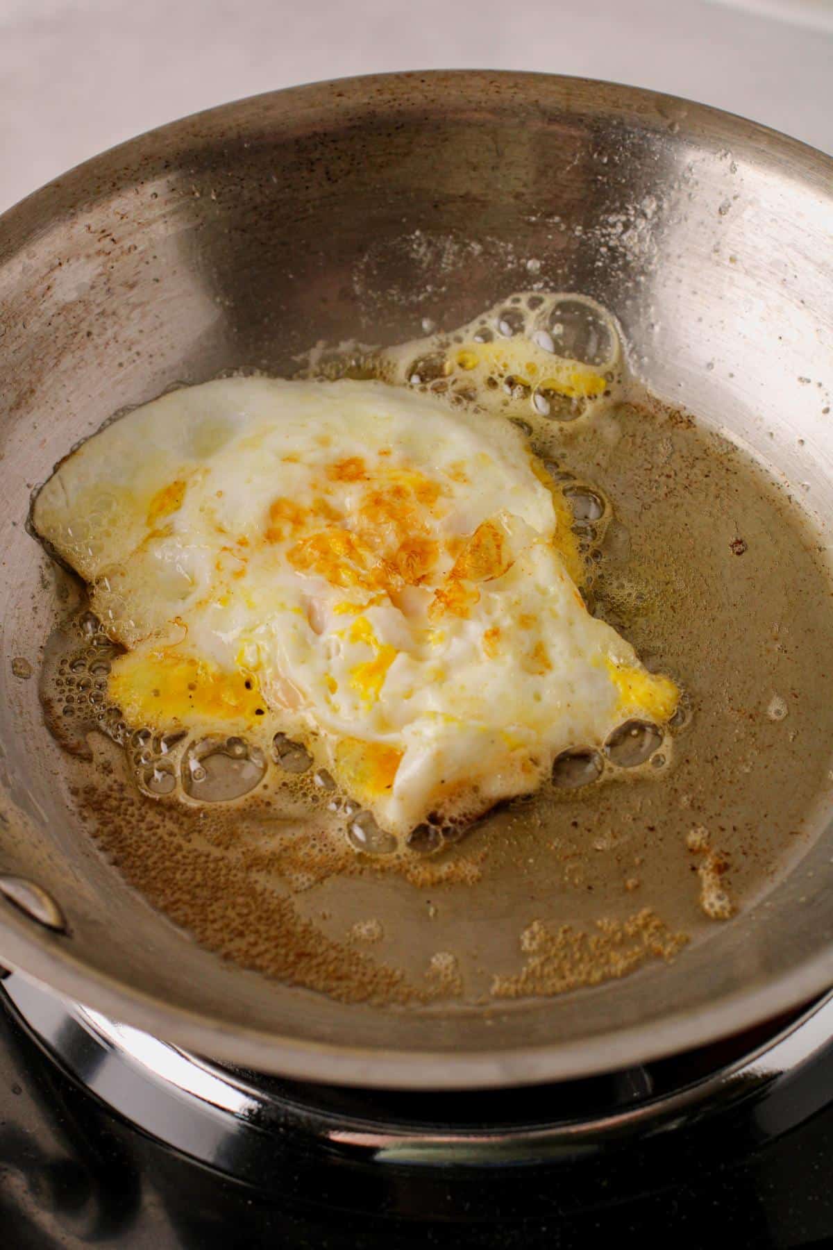 Egg flipped with top side cooked.