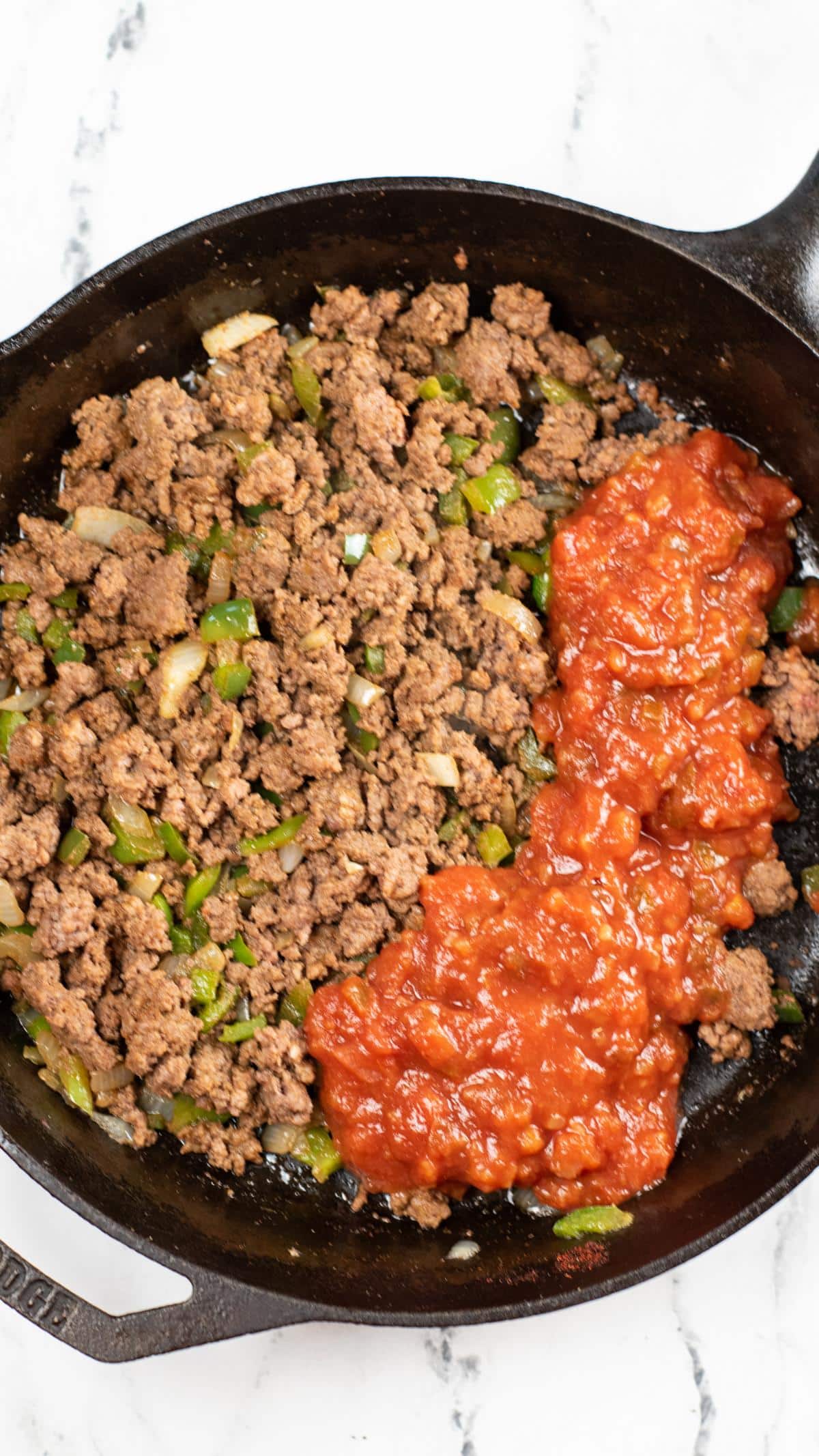 Cooked meat mixture with salsa added to pan.