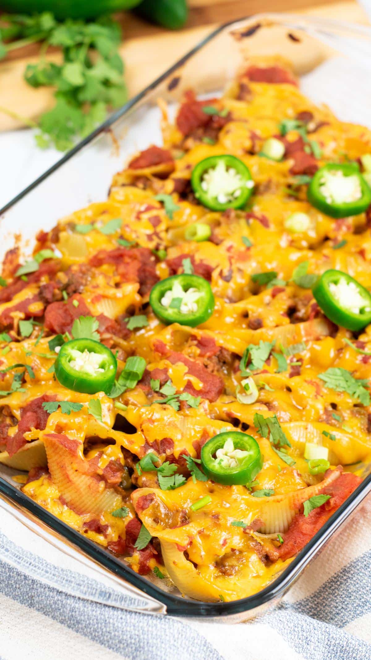 Cooked stuffed taco shells in casserole dish.