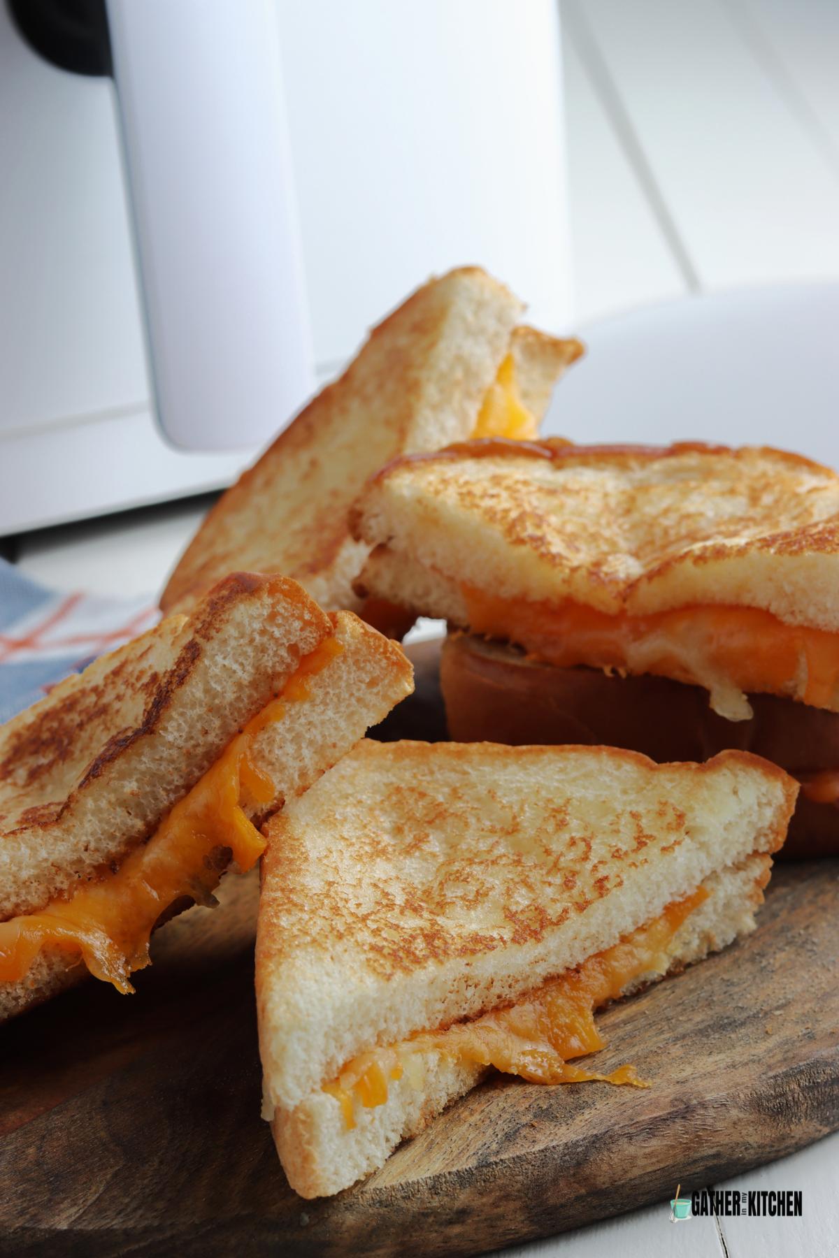 5 halves of air fryer grilled cheese sandwiches on a cutting board.
