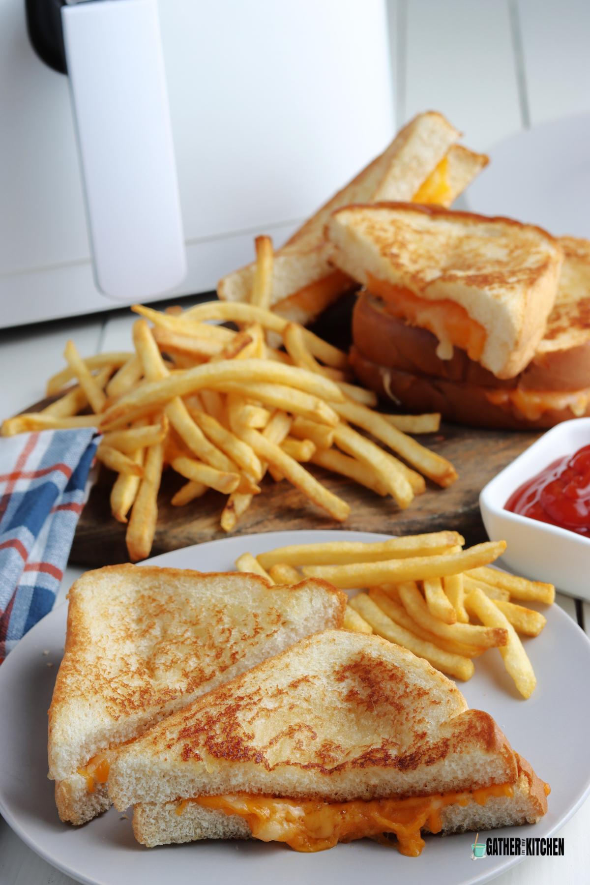 Two halves of air fryer cheese sandwich on a plate with fries next to it.