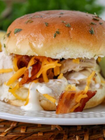 Side view of bacon chicken ranch sliders on a plate.