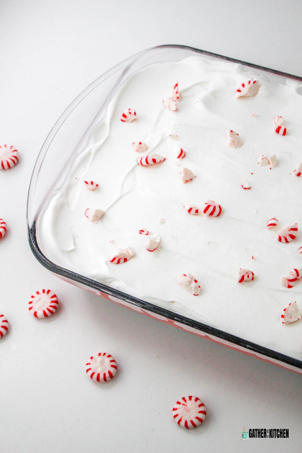 Whipped topping spread over layers in baking dish and topped with pieces of peppermint candy.