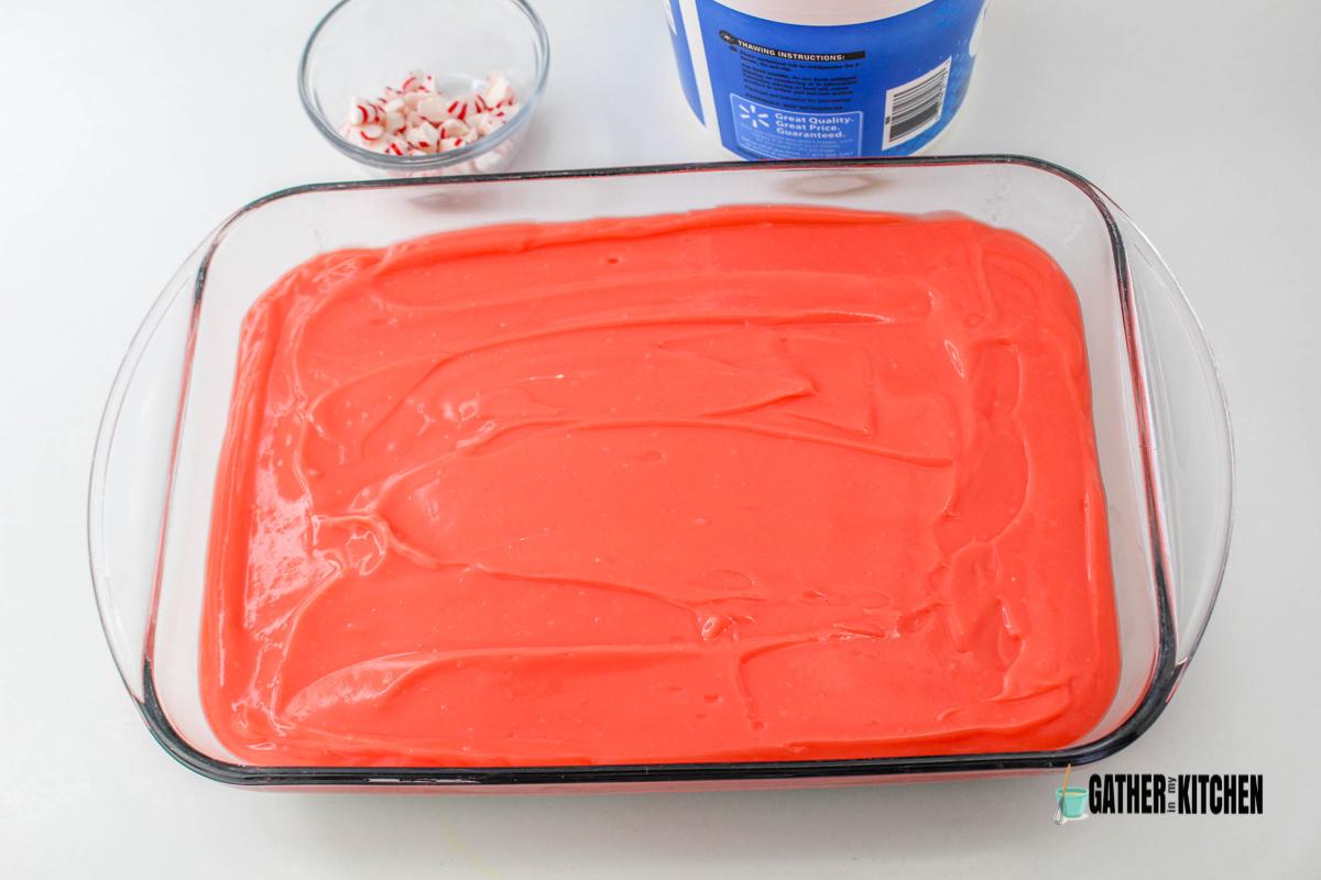 Red vanilla pudding spread in baking dish.