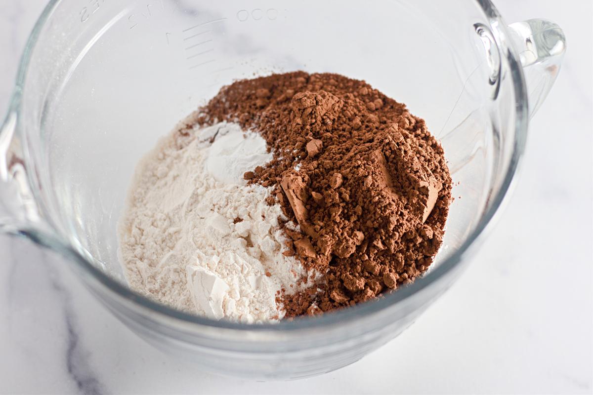 Large measuring cup with flour, cocoa powder and baking powder.