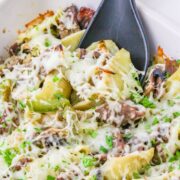 Philly cheesesteak casserole in a dish with a spoon.